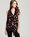 A punchy lipstick print and a downtown-ready oversized silhouette elevate this draped DKNYC tie-neck blouse.