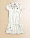 A drop-waist dress with rugby-inspired details for the perfect mix of utility and girlie style.Shirt collarShort sleevesShoulder epauletsFront button placketButton flap-bellows pockets at chestDrop-waist drawstring with grosgrain ribbon tieCottonMachine washImported Please note: Number of buttons may vary depending on size ordered. 