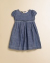 A captivating frock in soft chambray, with a crisply pleated Empire waist and sweet puffed sleeves.Round neckline with topstitchingShort puffed sleevesEmpire waist with stitched pleatsFull button back with check trimCottonMachine washImported Please note: Number of buttons may vary depending on size ordered. 