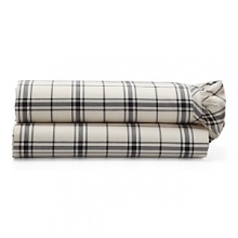 Dramatic black-and-cream checked sheets and pillowcases are edged in feminine pleated ruffles. Dramatic black-and-cream checked sheets and pillowcases are edged in feminine pleated ruffles.