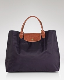 A timeless and durable nod to French style, this Longchamp nylon tote perfects daily errand-running for the très chic girl about town. A timeless and durable nod to French style, this Longchamp nylon tote perfects daily errand-running for the très chic girl about town.