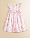 A charmingly traditional dress in crisp cotton features a dogwood floral pattern for a sweet summer look.RoundneckShort flutter sleevesBack buttonsGathered empire waist with flower detailFull skirt with ruffled petticoatCottonMachine washImported Please note: Number of buttons may vary depending on size ordered. 