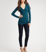 Body-skimming stretch knit, finished with layered shrug shoulders.V neckline Long sleeves Ruched back panels About 28 from shoulder to hem 94% rayon/6% spandex Dry clean Made in USA