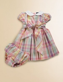 Pretty cotton madras dress in a sweet empire silhouette, perfect for the warmer-weather seasons.Solid Peter Pan collarShort puffed sleevesCovered buttons at back of neckRuffle trimmed empire waist with bow tie detailPleated, lined skirtMatching bloomersCottonMachine washImported Please note: Number of buttons may vary depending on size ordered. 
