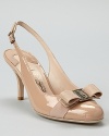 A logo ornament tops the grosgrain-wrapped toes of these chic, sleek patent heels. From Salvatore Ferragamo.