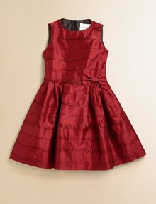 Shiny taffeta, crisp and classic, is sweetly styled with tiny pintucked pleats, a bow at the waist and a sweeping full skirt.Jewel neckline Sleeveless Pleated full skirt Bow at waist Back zip closure Fully lined Acetate; dry clean Made in USA