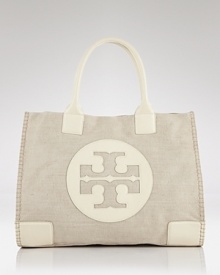 Introduce destination chic into your accessories portfolio with Tory Burch's canvas tote. This logo-stamped bag boasts ample room, making it the ultimate runway-to-resort companion. Introduce destination chic into your accessories portfolio with Tory Burch's canvas tote. This logo-stamped bag boasts ample room, making it the ultimate runway-to-resort companion.