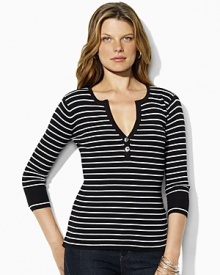 A deep split neckline finished with silver-toned buttons lends modern allure to a classic striped henley in soft ribbed cotton.