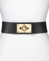 A bold turnlock asserts tough-girl glamour on this Tory Burch belt, composed of smooth leather and elastic. It's an edgy must-have over a body-con mini dress with towering stiletto booties.