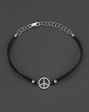 Diamonds, set in white gold, form a dazzling peace sign on this leather bracelet from Meira T.