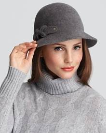 An ultra chic cloche hat with a detachable bow embellished strap and rollable functionality for easy portability.