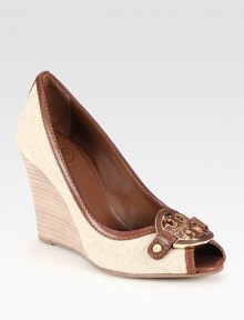 Elevated by a stacked heel, this slightly textured burlap design has intricately stitched leather trim and a goldtone designer emblem. Stacked wedge, 4 (100mm)Burlap and leather upperLeather liningRubber solePadded insoleImportedOUR FIT MODEL RECOMMENDS ordering true size. 