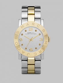 A sleek timepiece with a logo etched bezel and dazzling crystal markers. Quartz movementWater resistant to 5 ATMRound stainless steel case, 36mm (1.4) Logo etched goldtone ion-plated bezelSilver dialCrystal and numeric hour markersSecond hand Two-tone stainless steel link braceletImported 