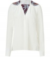 The classic white shirt gets a boho-inspired redux with this printed version from Schumacher - V-neck, gathered shoulders with printed detail, front button placket, long sleeves, asymmetric hem with vents, relaxed fit - Wear with flared jeans and platform heels