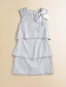 A tiered, charmeuse design is embellished with a standout bow and silver dots for festive, fun appeal.Round necklineSleevelessBack zipperTiered silhouettePolyesterMachine washImported