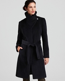 The sculpted silhouette on this Calvin Klein belted coat features a warm funnel neck and tie closure for a cinched waist. The sculpted silhouette on this Calvin Klein belted coat features a warm funnel neck and tie closure for a cinched waist.