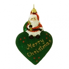 A little Santa sits atop a glittered puffed heart to wish you a Merry Christmas. A little Santa sits atop a glittered puffed heart to wish you a Merry Christmas.