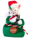 The cat's out of the bag and clutching a different type of holiday bubbly in this cheery Coca-Cola ornament. Crafted with the soft features and unmistakable style of Annalee.