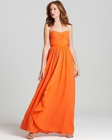 This stunning, vibrantly hued BCBGMAXAZRIA strapless gown features detailed pleating at the bodice and a cascading skirt.