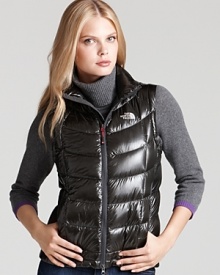 A perfect layering piece, this vest is a must have for outdoor activities on brisk winter days. A short length and glossy finish add a flirty feel to this sporty-chic layer. A perfect layering piece, this vest is a must have for outdoor activities on brisk winter days. A short length and glossy finish add a flirty feel to this sporty-chic layer.