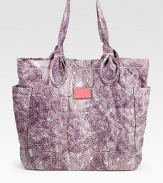 An anything but basic carryall of sleek nylon, featuring a colorful abstract print and signature letter stitching. Double top handles, 9 dropMagnetic snap closureTwo outside open pocketsOne inside zip pocketTwo inside open pocketsFully lined13W X 14¾H X 4½DImported