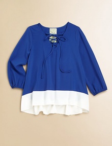 Your little girl will float away in this airy, long-sleeved pullover, defined by a lace-up neckline, colorblocked design and an on-trend hi-lo hem.Laced V-neckLong sleeves with elastic cuffsPullover styleHi-lo hemPolyesterDry cleanMade in the USA of imported fabric Your little girl will float away in this airy, long-sleeved pullover, defined by a lace-up neckline, colorblocked design and an on-trend hi-lo hem.Laced V-neckLong sleeves with elastic cuffsPullover styleHi-lo hemPolyesterDry cleanMade in the USA of imported fabric