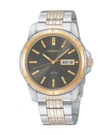 Handsome styling to outlast trends, this Seiko watch is the epitome of classic. Two-tone stainless steel bracelet and round case with goldtone bezel. Brushed charcoal dial features goldtone stick indices with luminous tips, day and date window at three o'clock, luminous hands and logo. Quartz movement. Water resistant to 100 meters. Three-year limited warranty.