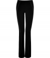 Flattering black pants with taped seams from Donna Karan - These curve-hugging pants make a seamless transition from office to evening - Slim fit, side-seaming detail, slightly flared leg - Style with an oversized cashmere pullover, a draped leather jacket, and platforms