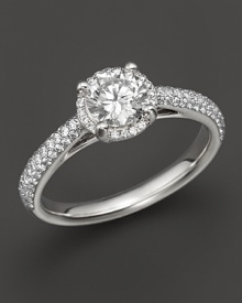 Win her heart with this stunning engagement ring. White gold band with diamond pavé stones and a brilliant round center diamond. Win her heart with this stunning engagement ring. White gold band with diamond pavé stones and a brilliant round center diamond.