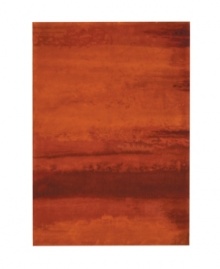 Abstract and dramatic, this handcrafted wool rug features a rich spectrum of shades from burnt orange tones to deep reds. The ethereal coloration pattern is reminiscent of a vivid sky at sunset. Luster-wash finish creates gently-diffused color variation.