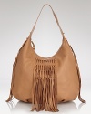 Stunning leather fringe on Carlos Falchi's hobo adds instant interest. Designed with exterior pockets and a single shoulder strap, it's a dressed-up take on the classic day bag.