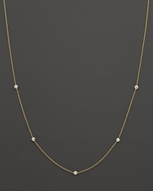 A yellow gold chain with five bezel-set diamond stations.