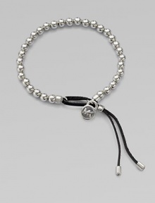 A smooth, beaded design with a logo lock charm and an adjustable leather closure. Silvertone metalDiameter, about 2.5Slip-on style with adjustable leather closureImported 