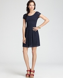 Ladylike eyelet decorates a knit Aqua dress touting the season's must-have pleated skirt for a delightful daytime look.