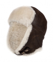 Both comfortable and stylish, UGG Australias shearling lined leather trapper cap is an ultra cozy cold weather must - Cream shearling lining, chocolate leather outside, logo snap strap - Wear with puffy parkas and matching shearling boots