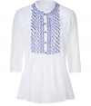 Stylish white tunic top with blue embroidery from Ermanno Scervino - Get easy, breezy effortless style in this chic tunic - Rounded neckline, button front placket with embroidered detail, front pleating, 3/4-sleeves - Wear with skinny jeans, a shawl cardigan, and over-the-knee boots