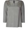 Elevate your go-to casual favorites with this ultra-chic embellished tunic - Round neck, three-quarter sleeves, bead embellished shoulders, relaxed silhouette, back button half placket - Style with high waist skinnies and wedge heels