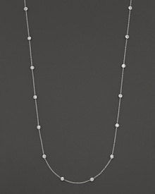 A long white gold chain is spaced with fifteen bezel-set, diamond stations.