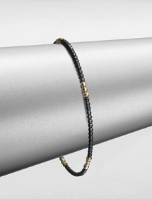 A simple chic piece that features faceted beads in blackened sterling silver accented with five, 14k gold beaded sections. Blackened sterling silver14k goldDiameter, about 2.5Slip-on styleMade in USA