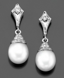 Majestic elegance: cultured freshwater pearl (7-7-1/2 mm) drop earrings with shimmering diamond accents in a 14k white gold setting. Approximate length: 3/4 inch. Majestic elegance: cultured freshwater pearl (7-7-1/2 mm) drop earrings with shimmering diamond accents in a 14k white gold setting. Approximate length: 3/4 inch.