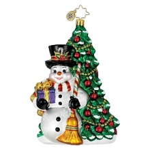 A jolly snowman with gift and broom in hand stands in front of a holiday decorated tree. A jolly snowman with gift and broom in hand stands in front of a holiday decorated tree.