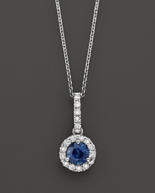 Diamonds surround a sapphire center stone in this elegant 14K white gold pendant necklace.