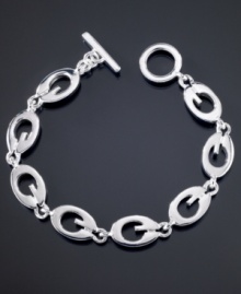 Totally trendy, this GUESS logo link bracelet goes with all of your looks. Featuring G logo links crafted in silvertone mixed metal. Approximate length: 7-1/2 inches.