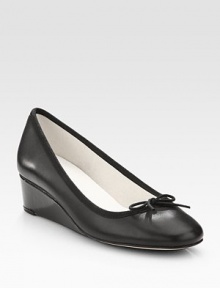 An elevated self-covered wedge silhouette of patent leather, topped with a pretty grosgrain bow. Self-covered wedge, 1½ (40mm)Leather and grosgrain upperLeather liningRubber solePadded insoleMade in France