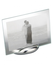 Keep memories fresh in the modern Elbow picture frame. A sculpted metal base turns back in an elegant curve, fitted with sheets of clear glass for displaying any photo, vertical or horizontal. Designed by Neil Cohen for Nambe. Keep memories fresh in the modern Elbow picture frame. A sculpted metal base turns back in an elegant curve, fitted with sheets of clear glass for displaying any photo, vertical or horizontal. Designed by Neil Cohen for Nambe.