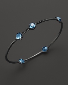 A modern sterling silver bangle with blue topaz stations from Ippolita.