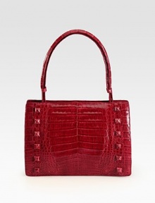 A glossy crocodile design with self covered stud accents.Adjustable top handle, 7½-8 dropHinged magnetic closureProtective crocodile covered feetOne inside zip pocketTwo inside open pocketsSuede lining11W X 7½H X 3DImported