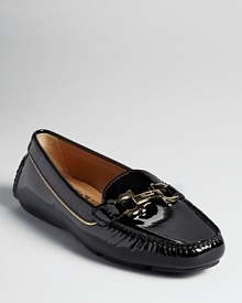 Patent leather and a golden logo accent make a streamlined Salvatore Ferragamo loafer shine.