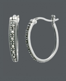 Take traditional hoops to a new level with this standout style by Genevieve & Grace. Oval-shaped hoops feature a polished sterling silver setting and glittering, round-cut marcasite. Approximate diameter: 3/4 inch. Take traditional hoops to a new level with this standout style by Genevieve & Grace. Oval-shaped hoops feature a polished sterling silver setting and glittering, round-cut marcasite. Approximate diameter: 3/4 inch.