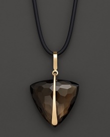 Faceted, trillion cut smoky quartz, set in 14K yellow gold, hangs from a cord necklace.